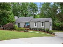 Charming single-story home with a well-maintained lawn, neat landscaping, and light-blue front door at 3006 Alberta Dr, Marietta, GA 30062