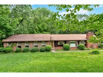 Charming ranch-style home with a brick facade, well-maintained lawn, and mature trees offering plenty of shade at 124 Chaseland Rd, Atlanta, GA 30328