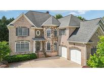 Charming brick two-story home with a well-manicured lawn and attached two-car garage at 2871 Trailing Ivy Way, Buford, GA 30519