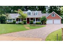 Charming brick and siding home featuring a lush front yard and a welcoming driveway at 1477 Triple Creek Nw Ct, Kennesaw, GA 30144