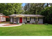 Charming single-story home featuring a red door, painted brick, and a lush green lawn at 3372 Ward Drive Southwest Sw Dr, Atlanta, GA 30354