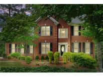 Traditional two-story brick home with black shutters and a manicured lawn and mature shade trees at 3642 Fowler Rdg, Douglasville, GA 30135