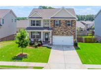Charming two-story home featuring a stone facade, well-manicured lawn, and a welcoming front porch at 431 Hinton Farm Way, Dacula, GA 30019