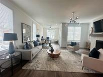 Bright, open living room with hardwood floors, neutral furniture, and large windows for plenty of natural light at 502 Healy Dr # 76, Cumming, GA 30040