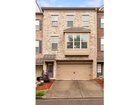 Charming brick townhouse with a two-car garage and a bay window feature at 275 Blue Pointe Ct, Suwanee, GA 30024