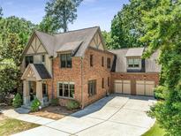 Charming brick two-story home with well-manicured lawn, mature trees and a three car garage at 504 S Westminster Ne Way, Atlanta, GA 30307