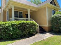 Charming home featuring a welcoming front porch with classic white columns and a well-manicured hedge at 937 Capitol View Nw Ave, Atlanta, GA 30318