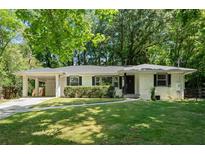 Charming ranch home featuring a spacious front yard, carport, and a classic white brick facade at 3180 Rehoboth Dr, Decatur, GA 30033