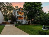 Charming two-story home boasting a double front porch and well-manicured lawn at sunset at 891 Paoli Se Ave, Atlanta, GA 30316