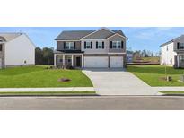 Charming two-story home featuring a well-manicured lawn, and a two-car garage at 712 Curb Ct, Locust Grove, GA 30248
