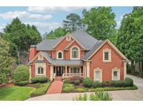 Stunning two-story brick home with manicured landscaping and charming front porch at 8250 Saint Marlo Fairway Dr, Duluth, GA 30097