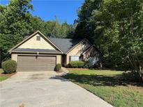 Charming single-Gathering home with a two-car garage, manicured lawn, and mature trees at 1280 Waterwood Dr, Loganville, GA 30052