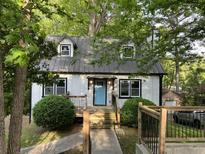 Charming home with a metal roof, light blue front door, and lush landscaping at 743 San Fernando Se Dr, Smyrna, GA 30080