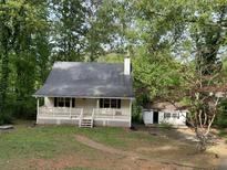 Charming exterior featuring a classic design, porch, and ample natural lighting from surrounding trees at 1978 Winding Creek Sw Ln, Marietta, GA 30064