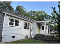 Charming exterior view of home featuring gray siding, a covered front porch, and well-maintained landscaping at 3831 Dillard St, Powder Springs, GA 30127