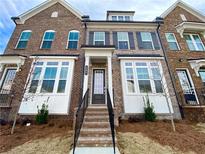 Beautiful brick townhome featuring a welcoming entrance and a well-manicured front yard landscape at 741 Cordele Ln, Sugar Hill, GA 30518