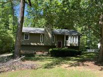 Inviting home boasts a charming exterior with lush greenery and unique architectural details at 816 Cedar Lake Se Dr, Conyers, GA 30094