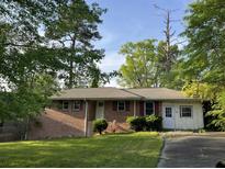 Charming single-story brick home with a well-manicured front yard and mature trees at 2039 Harwinor Se Rd, Smyrna, GA 30082