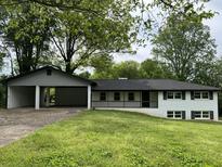 Charming one-story house featuring a carport and a well-maintained front yard with large trees at 644 Cambridge Dr, Marietta, GA 30066
