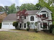 Charming two-story home with a three-car garage, gray exterior, and beautifully landscaped front yard at 730 Redlion Run, Alpharetta, GA 30022