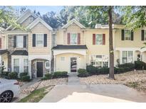 Charming townhome with welcoming facade and well-maintained landscaping at 6073 Camden Forrest Dr, Riverdale, GA 30296