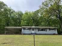 Ranch-style home with light blue siding, black shutters, a carport, and a chain-link fence at 172 Camp Sunrise Nw Rd, Cartersville, GA 30121