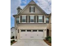 Charming two-story home featuring neutral siding, a front-entry two-car garage, and decorative window shutters at 6128 Lanier Harbor Lndg, Buford, GA 30518