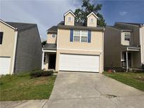 Two-story home featuring a two-car garage, dormer windows, and neutral siding at 1263 Brookstone Rd, Atlanta, GA 30349