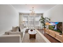 Bright living room features a chandelier, white couch, and hardwood floors at 1850 Cotillion Dr # 2304, Atlanta, GA 30338