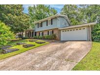 Charming two-story home with a large driveway and attached two-car garage, surrounded by lush greenery at 2146 Chevy Chase Ln, Decatur, GA 30032