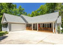 Charming single-story home featuring a spacious porch, two-car garage, and professionally landscaped front yard at 390 Rock Springs Pass, Dallas, GA 30157