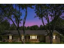 Charming single-story brick home featuring a well-maintained lawn and mature trees at 4911 Old Douglasville Rd, Lithia Springs, GA 30122
