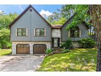 Charming exterior of gray home featuring brick accents, two-car garage, and well-maintained lawn at 143 Frances Dr, Dallas, GA 30157