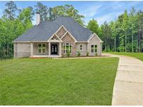 Charming single-story home with a brick and stone facade, large windows, and a well-manicured lawn at 244 Coastline Road Rd, Fayetteville, GA 30214