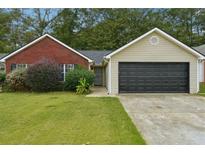 Charming single-story home with brick and siding, a well-manicured lawn, and an attached two-car garage at 11529 Vinea Ln, Hampton, GA 30228