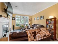 Inviting living room featuring a fireplace, large windows, and comfortable seating arrangement at 220 Renaissance Ne Pkwy # 1115, Atlanta, GA 30308
