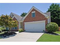 Charming brick home with a two-car garage, landscaped yard, and mature tree at 314 Santa Anita Ave, Woodstock, GA 30189