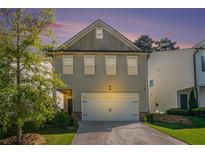 Charming home featuring a two-car garage, well-maintained lawn and mature tree under a beautiful, colorful sunset sky at 4406 Richmond Court Ct, Stone Mountain, GA 30083