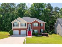 Charming two-story home with a manicured lawn, red stairs, a two-car garage, and a beautifully landscaped yard at 4348 Tillage Path, Douglasville, GA 30135