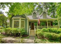 Charming home featuring a covered porch, bay window, and mature landscaping at 2165 Robin Hood Trl, Cumming, GA 30040