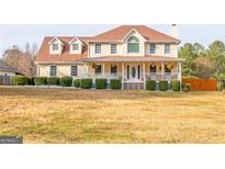 Charming two-story home with a welcoming front porch and well-manicured landscaping at 161 Honey Creek Rd, Mcdonough, GA 30252