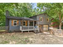 Charming two-story home with a cozy front porch, wooden shutters, and attached garage at 2642 Bridgehampton Sw Rd, Marietta, GA 30064