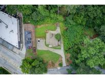 An aerial view showcases this single Gathering home nestled among mature trees with a long driveway at 2742 Alpine Rd, Atlanta, GA 30305