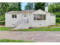 Charming white brick home featuring a well-manicured lawn and updated landscaping at 2742 Alpine Rd, Atlanta, GA 30305