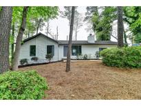 Home exterior surrounded by mature trees with front landscaping and wood siding at 396 Independence Dr, Jonesboro, GA 30238