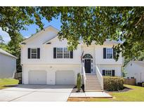 Charming two-story home featuring a two-car garage, black shutters, and a welcoming front porch with stairs at 6195 Queensdale Dr, Douglasville, GA 30135