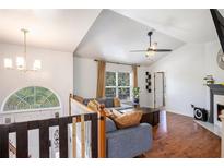 Bright living room featuring hardwood floors, fireplace, vaulted ceilings, and large windows providing natural light at 6195 Queensdale Dr, Douglasville, GA 30135