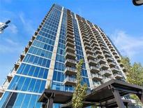 Modern high rise building exterior showing balconies and floor to ceiling windows against a blue sky at 855 Peachtree Ne St # 1406, Atlanta, GA 30308