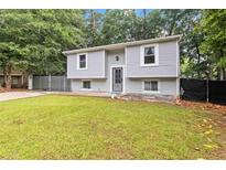 Charming home with a well-maintained lawn and mature trees providing shade at 2100 Scarbrough Rd, Stone Mountain, GA 30088