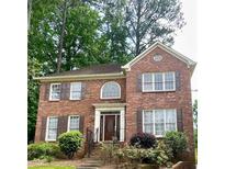 Charming two-story red brick home with landscaped front yard and decorative shutters at 3120 Saint Andrews Cir, Duluth, GA 30096
